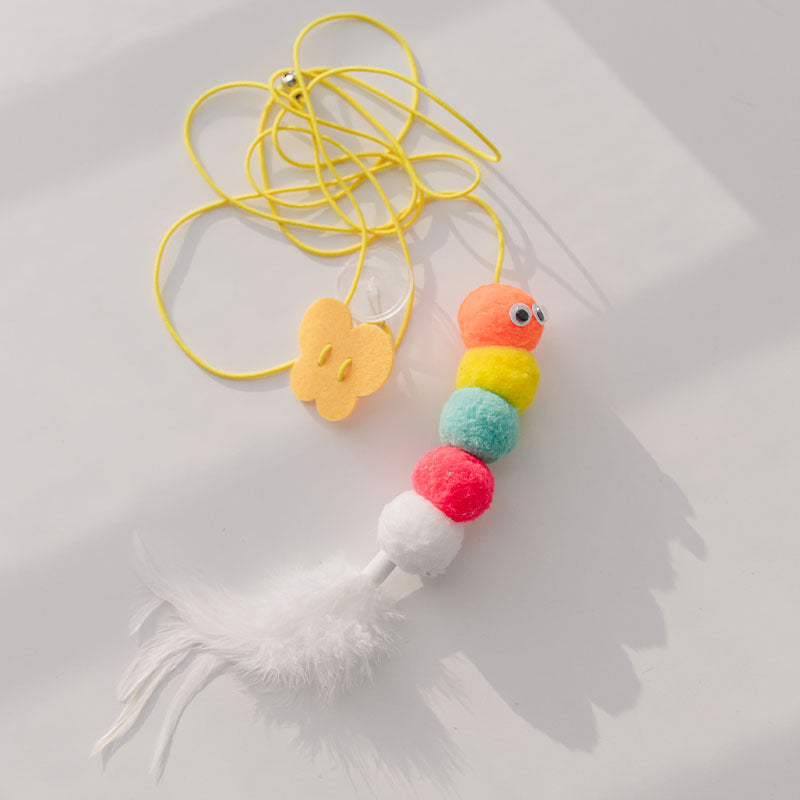 Colorful cat toy with pom-pom beads and a tassel on a light background