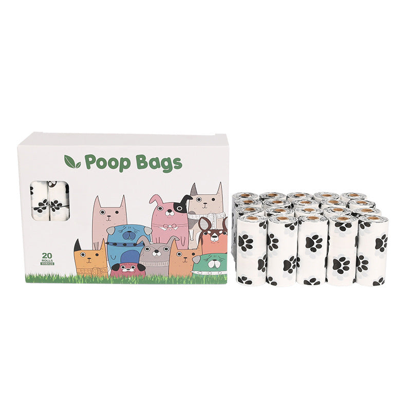 Box of dog poop bags with cartoon dog illustrations and multiple rolls of bags on a white background.