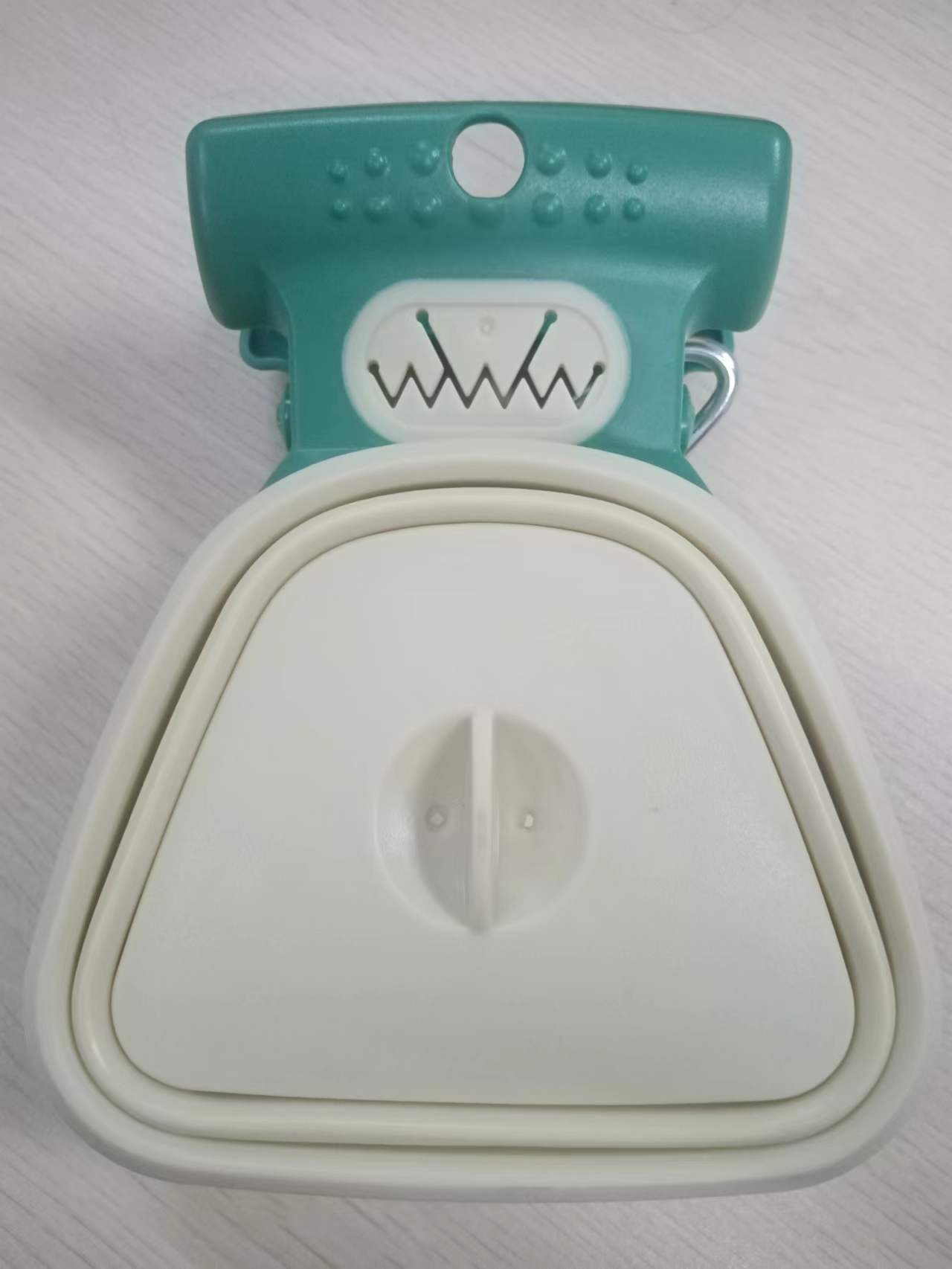 Teal and white pet muzzle on a light gray background