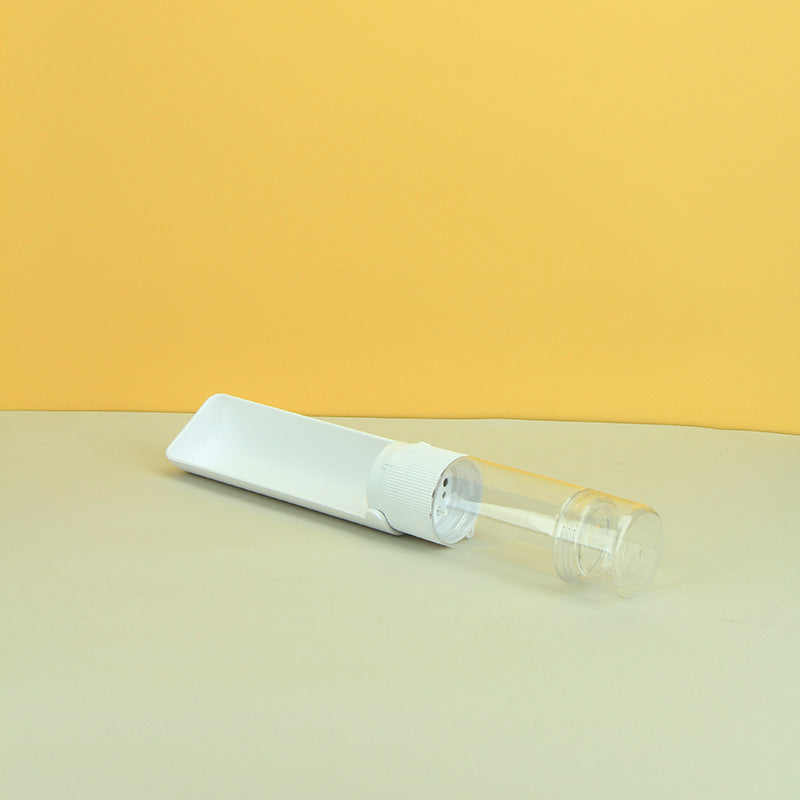 Clear plastic spray bottle with white cap on a beige surface against a yellow background