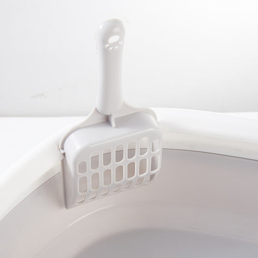 White pet litter scoop on a light gray background
