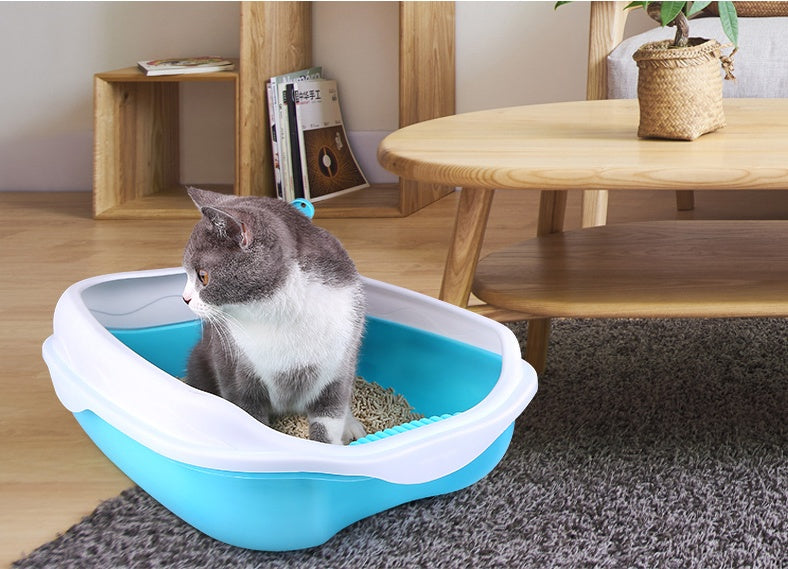 Cat using a blue and white litter box in a home setting with wooden furniture.