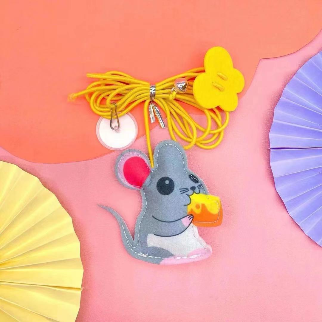 Mouse-shaped keychain with yellow lanyard on a pink background