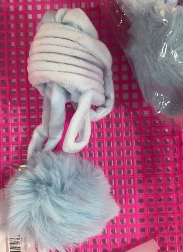 Pair of gray dog toys with pom-poms on a pink grid background