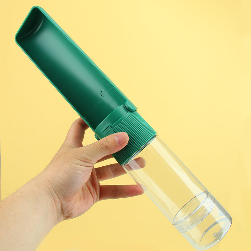 Hand holding a green pet water bottle against a yellow background
